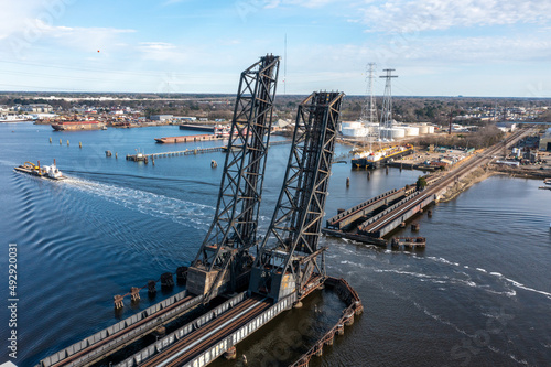 Railroad bridge in the vertical position as a tug and barge pass through photo
