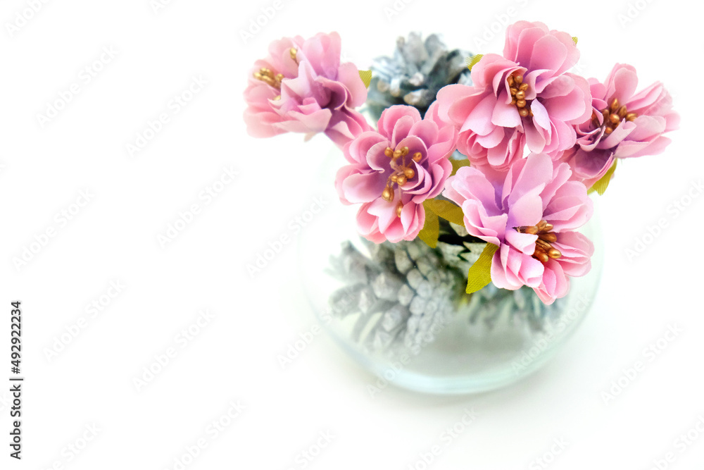 Artificial flower and glass vase with silver cone on white background, wedding interior detail close up Artificial flower and glass vase with silver cone on white background, wedding interior detail close up