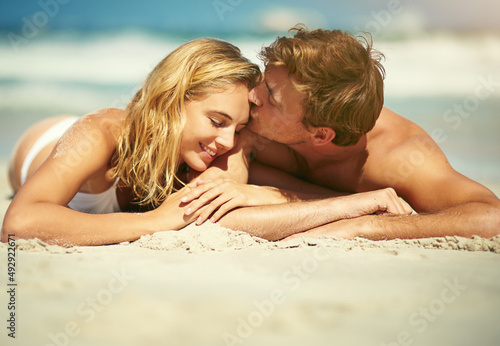 I love you. Cropped shot of an affectionate young couple lying on the beach. © C S W/peopleimages.com