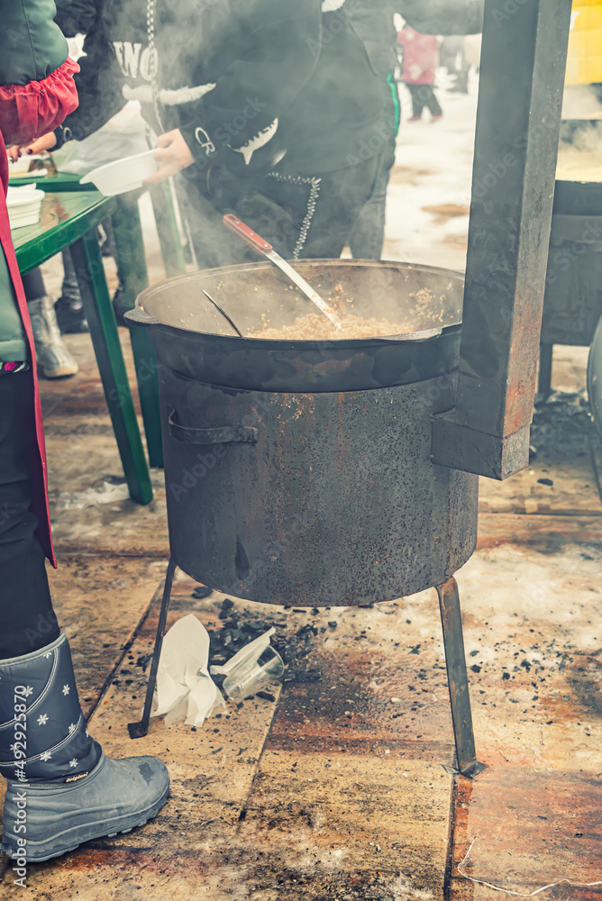 Φωτογραφία homeless refugees eating hot food on the street after fighting, preparing food i