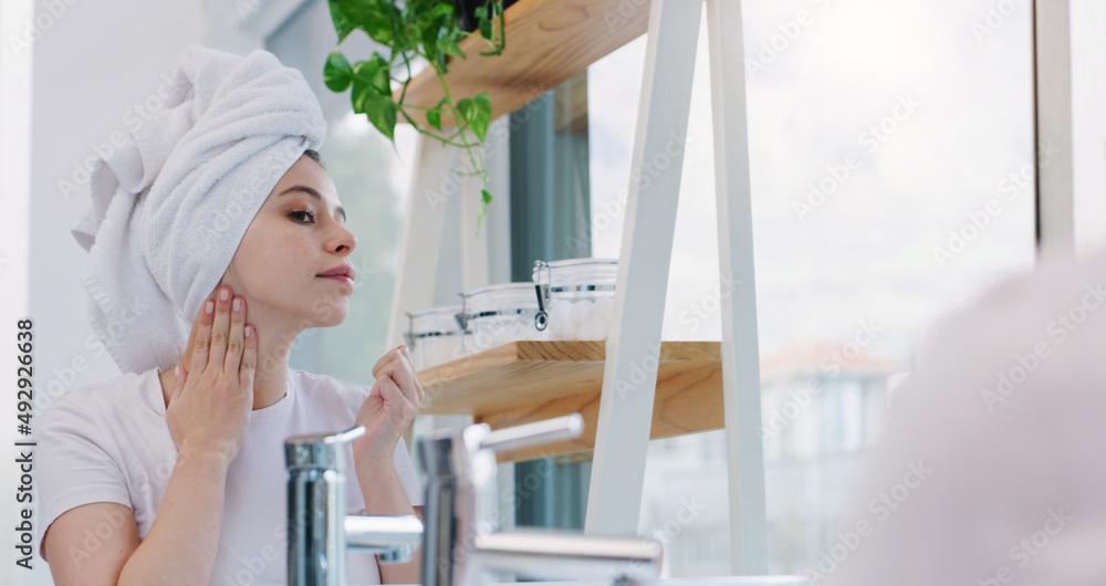 Always keeping my skin smooth and fresh. Shot of a young woman cleaning her face.