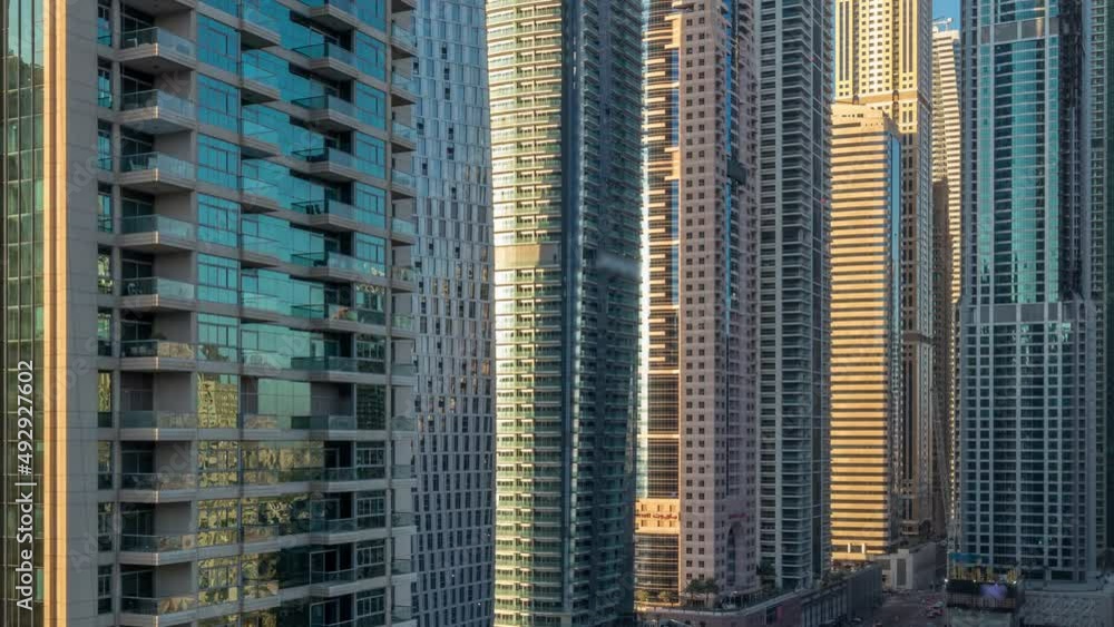 View of modern skyscrapers shining in sunset lights timelapse in Dubai Marina in Dubai, UAE. View of modern skyscrapers shining in sunset lights timelapse in Dubai Marina in Dubai, UAE.