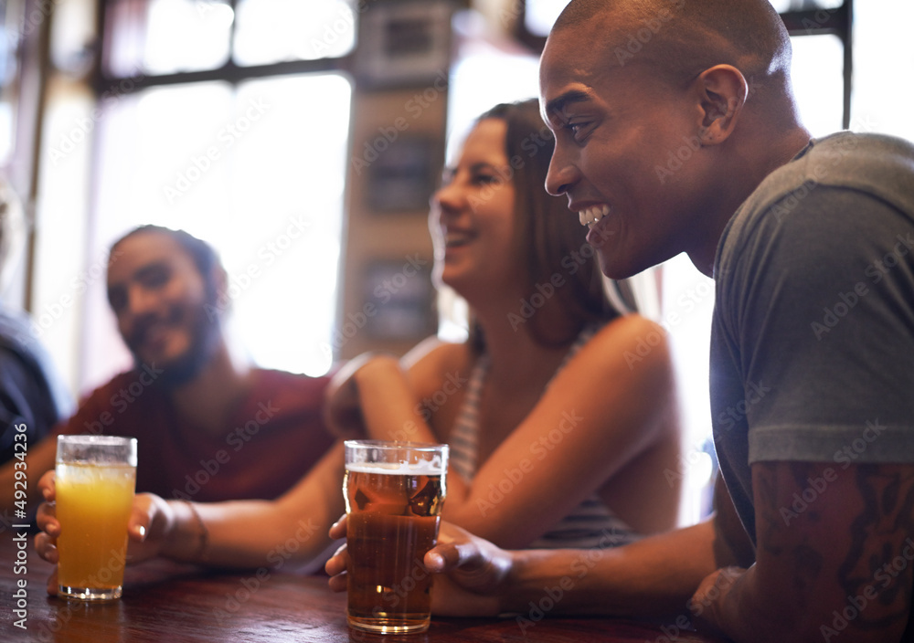 Our favorite local spot. A cropped shot of friends having drinks in a bar.