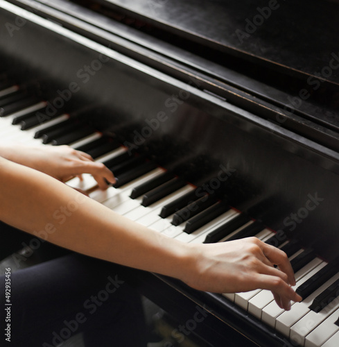 Reaching for the right notes. Cropped shot of hands on piano keys.