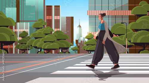 young girl in casual clothes crossing road fashionable woman walking city street cityscape background