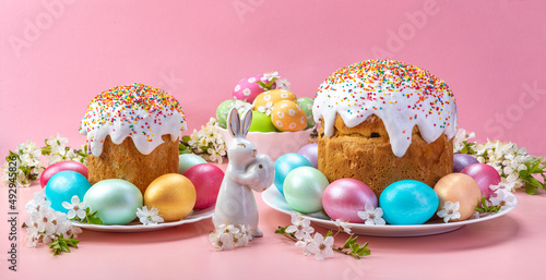 Easter cake with eggs porcelain rabbit and cherry blossoms. On a pink background.