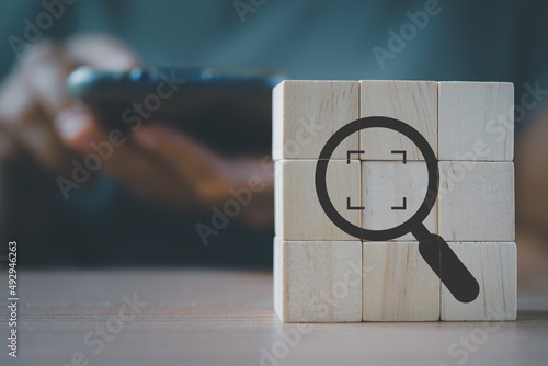 Photography wooden cube blocks with magnifying glass and cropped object symbols with blurred