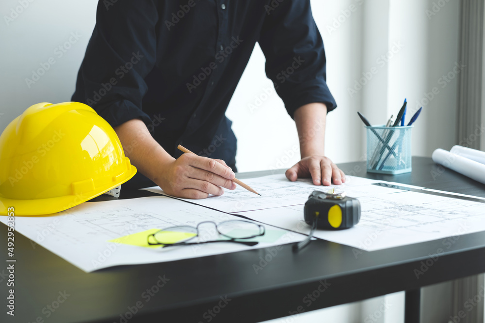 Architects or engineers working construction and drawing construction plans, printing, writing on-site construction sites. Home design concept Architects or engineers working construction and drawing construction plans, printing, writing on-site construction sites. Home design concept