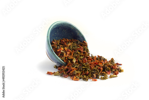 Dried Bell Peppers in Red and Green Pieces Spill from a Blue Potterry Bowl photo