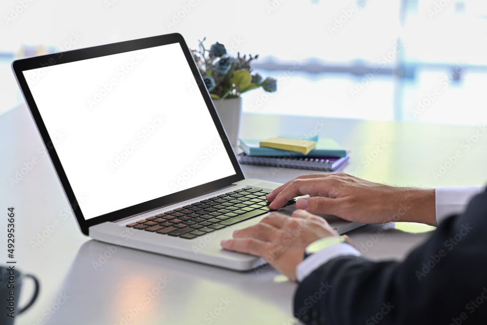 Cropped shot businessman sitting at office desk searching information on laptop computer. Cropped shot businessman sitting at office desk searching information on laptop computer.