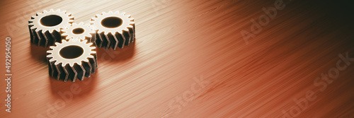 gear mechanism on a wooden surface (four worn metallic double helical gears) photo