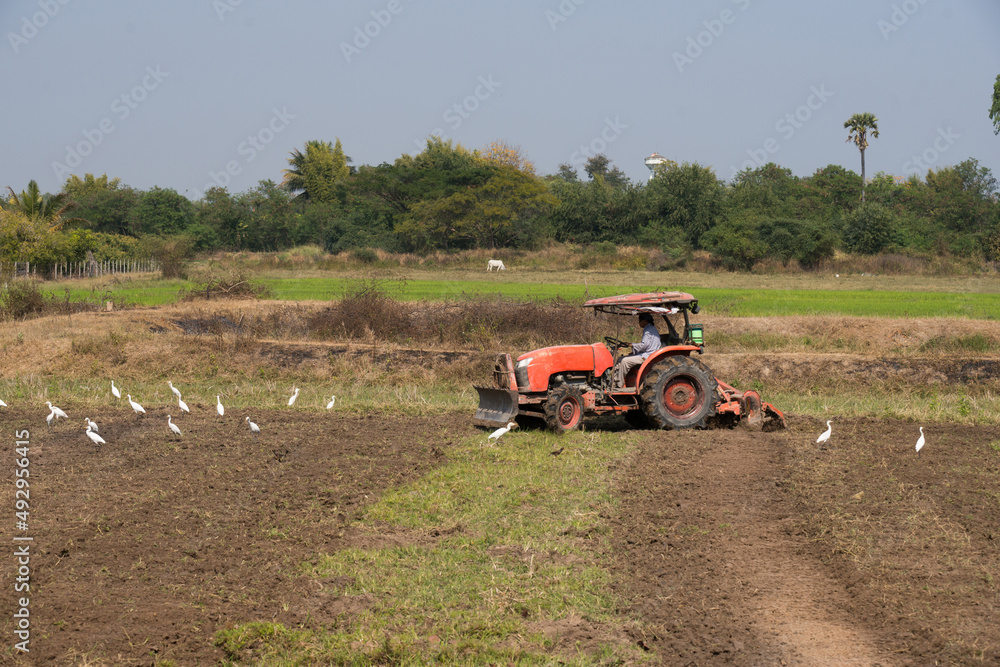 Tractor working in farmland. Agriculture industry for living in the country. Tractor working in farmland. Agriculture industry for living in the country.