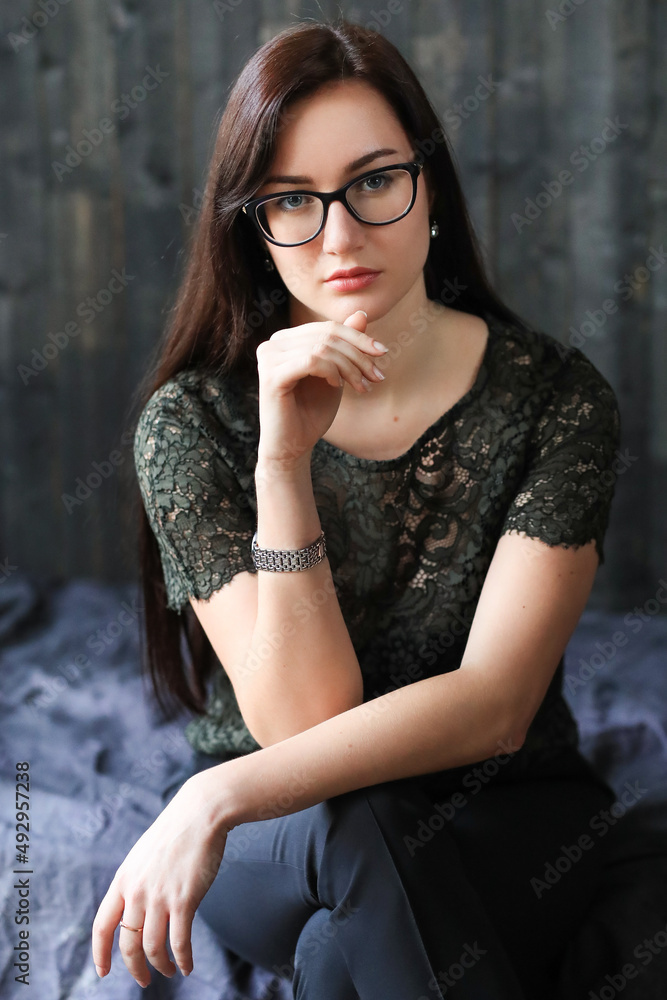 Fototapeta premium Stylish attractive young businesswoman with a lovely smile standing in the office grinning at the camera