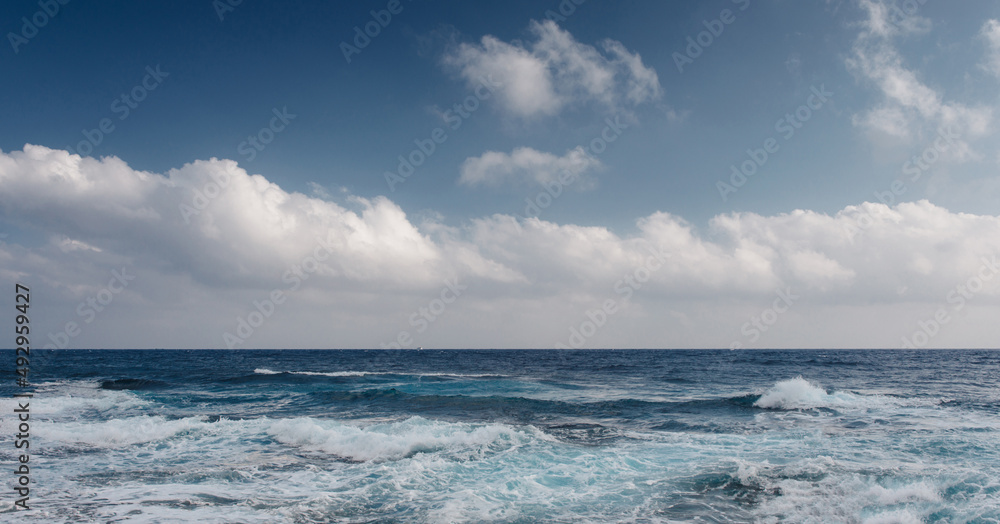 Sea waves crash on the rough rocky shore