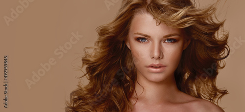 Close-up portrait. The face of a young beautiful woman with lush curly hair that is developing.