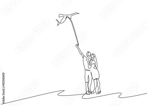 couple in love flying a kite on the beach in nature single line design