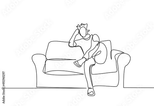 a bored person sitting on the sofa at home thinking