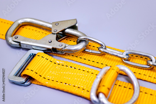 Safety belt for work at height with carabiner. Professional safety equipment for mountaineering and construction. Safety precautions. Close-up.