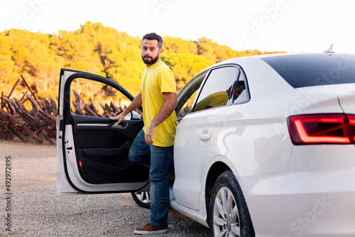 Canvastavla young bearded man getting out of his car