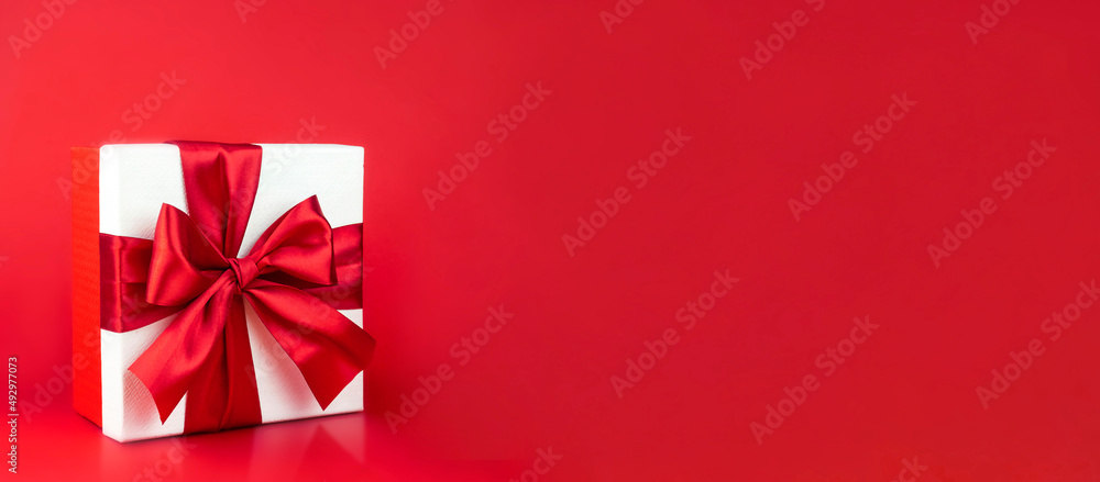 Box with red bow on red background for decoration. Promotional template. Holiday concept. Creative modern design. Box with red bow on red background for decoration. Promotional template. Holiday concept. Creative modern design.