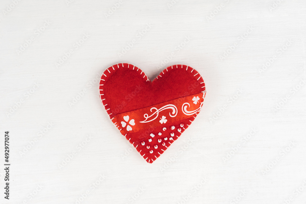 Top view Valentine's Day concept with copy space. Red textile heart on white wooden background Top view Valentine's Day concept with copy space. Red textile heart on white wooden background
