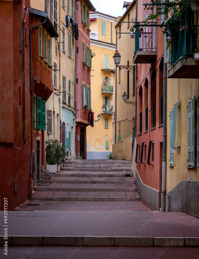 Cozy narrow street with beautiful and colorful buildings in Nice, France