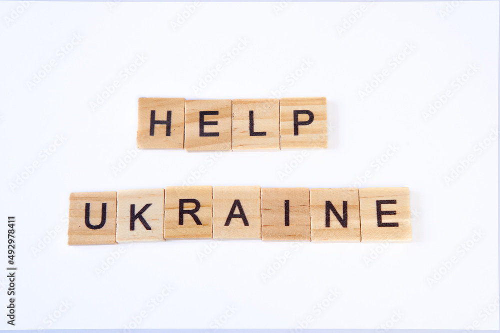 Top view of words help ukraine is laid out of wooden squares isolated on white background. Concept of peace, war in Ukraine,support,no war Top view of words help ukraine is laid out of wooden squares isolated on white background. Concept of peace, war in Ukraine,support,no war
