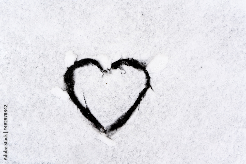 Heart symbol on snowy car glass with frash winter snow Heart symbol on snowy car glass with frash winter snow