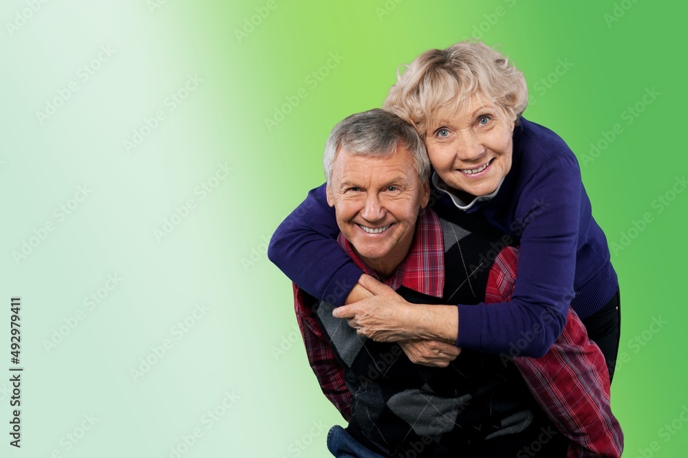 Senior man carrying his wife on his shoulders laughing. Attractive crazy old senior couple Senior man carrying his wife on his shoulders laughing. Attractive crazy old senior couple