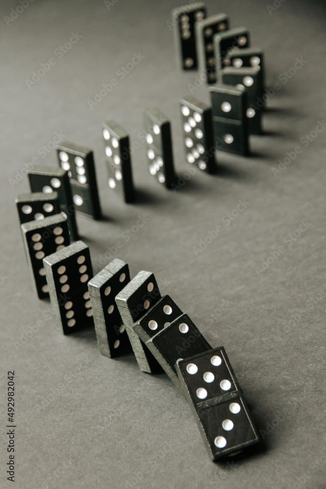 Black dominoes chain on dark table background Black dominoes chain on dark table background