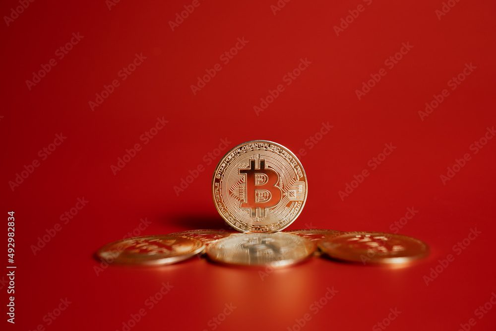 gold bitcoin coins on red background 