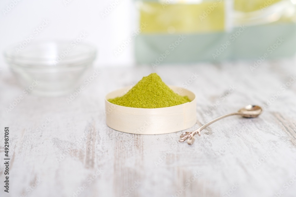 Green herbal detox powder in a plate on wooden table. Superfood. Organic eco health care. Vitamin nutrition and treatment. Immune system support. Alternative medicine. Dietary supplement, bowel clean. Green herbal detox powder in a plate on wooden table. Superfood. Organic eco health care. Vitamin nutrition and treatment. Immune system support. Alternative medicine. Dietary supplement, bowel clean.