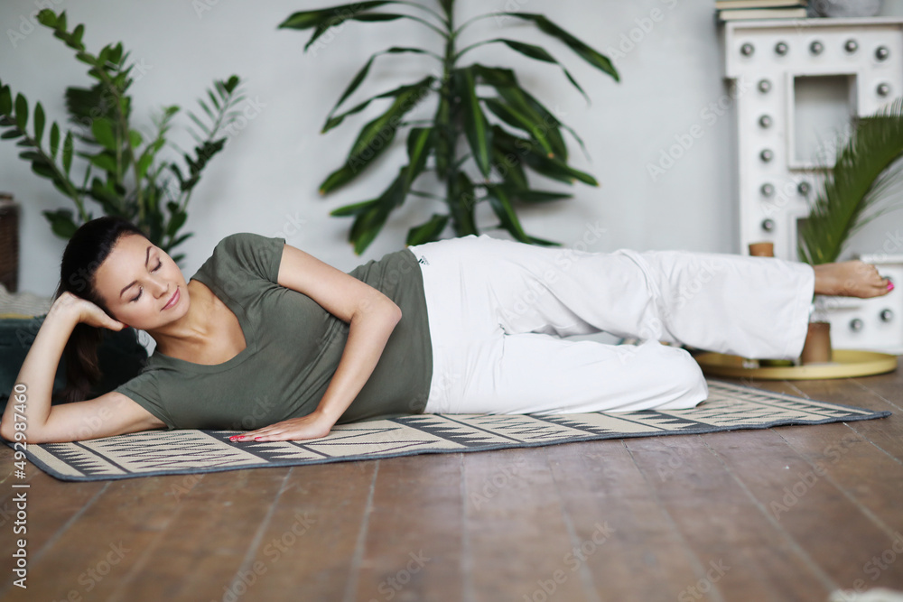Young happy healthy fitness beautiful woman female doing and workout on yoga mat opposite at modern bedroom at home. Young happy healthy fitness beautiful woman female doing and workout on yoga mat opposite at modern bedroom at home.