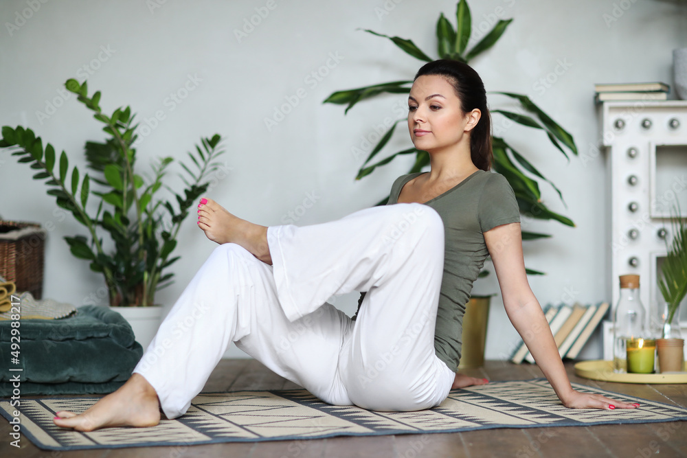 Young happy healthy fitness beautiful woman female doing and workout on yoga mat opposite at modern bedroom at home. Young happy healthy fitness beautiful woman female doing and workout on yoga mat opposite at modern bedroom at home.