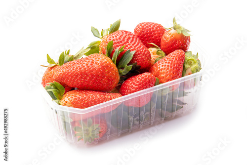 whole red strawberries in a plastic tray on a white background photo
