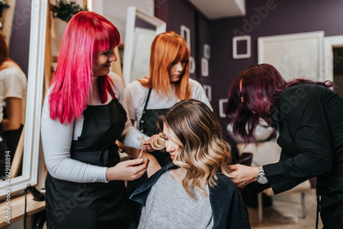 Beautiful hairstyle of young woman after dyeing hair and making highlights in hair salon.