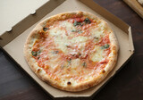 Fresh pizza with tomatoes, cheese and mushrooms on wooden table closeup
