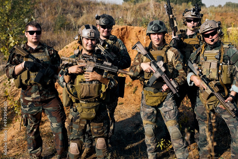military men, group of soldiers posing at camera carrying rifle guns