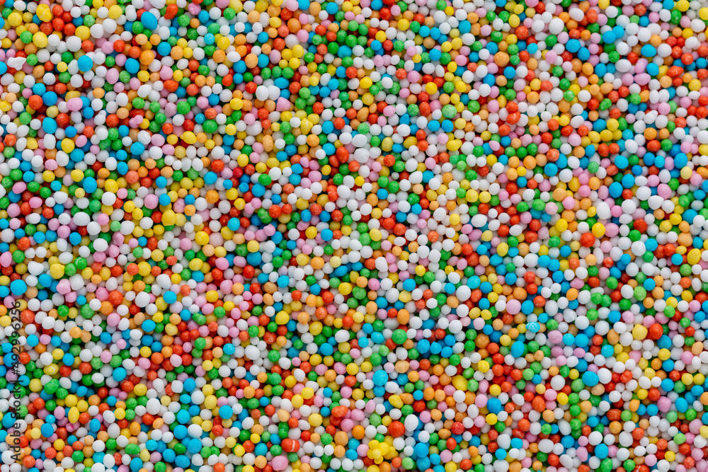 Thousands sprinkles tiny sugar beads for decorating cakes and desserts background. Thousands sprinkles tiny sugar beads for decorating cakes and desserts background.