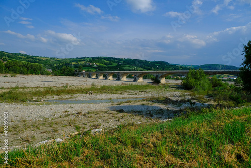 bridge over the mountains river Torrente Parma in summer across green hills. Langhirano, Emilia-Romagna, Italy