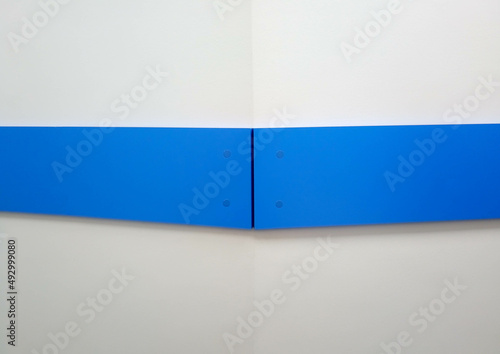 Background of the corner of a white wall with a blue stripe
