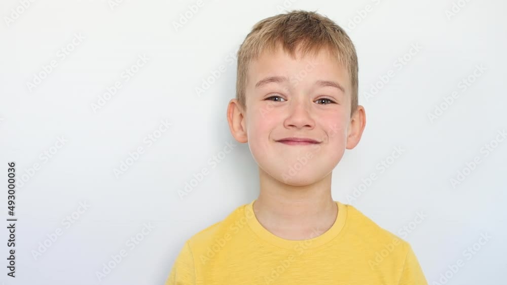 Boy is smiling standing against the wall Boy is smiling standing against the wall