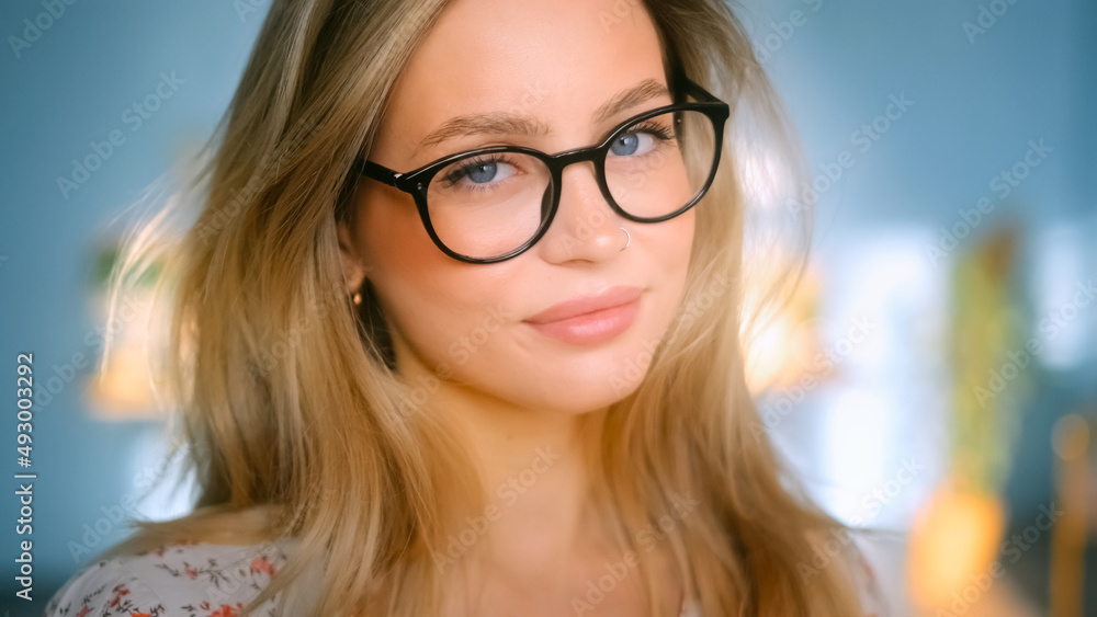 Portrait of happy smiling young attractive caucasian woman in eyeglasses looking on camera Portrait of happy smiling young attractive caucasian woman in eyeglasses looking on camera
