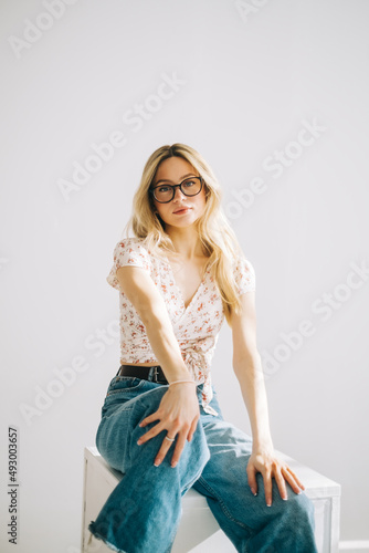 Portrait of attractive caucasian young woman in eyeglasses with blonde hair isolated on white background.