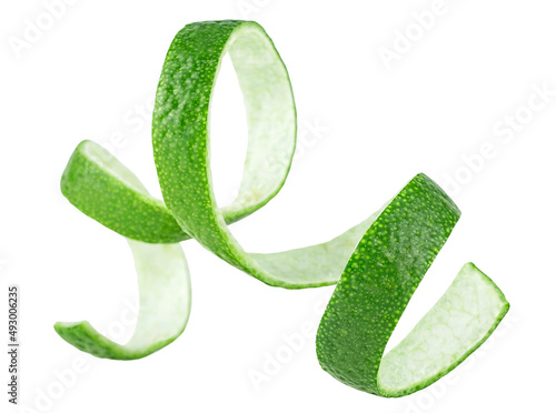 Curly lime peel twist isolated on a white background. Fresh lime fruit peel as cocktail ingredient.