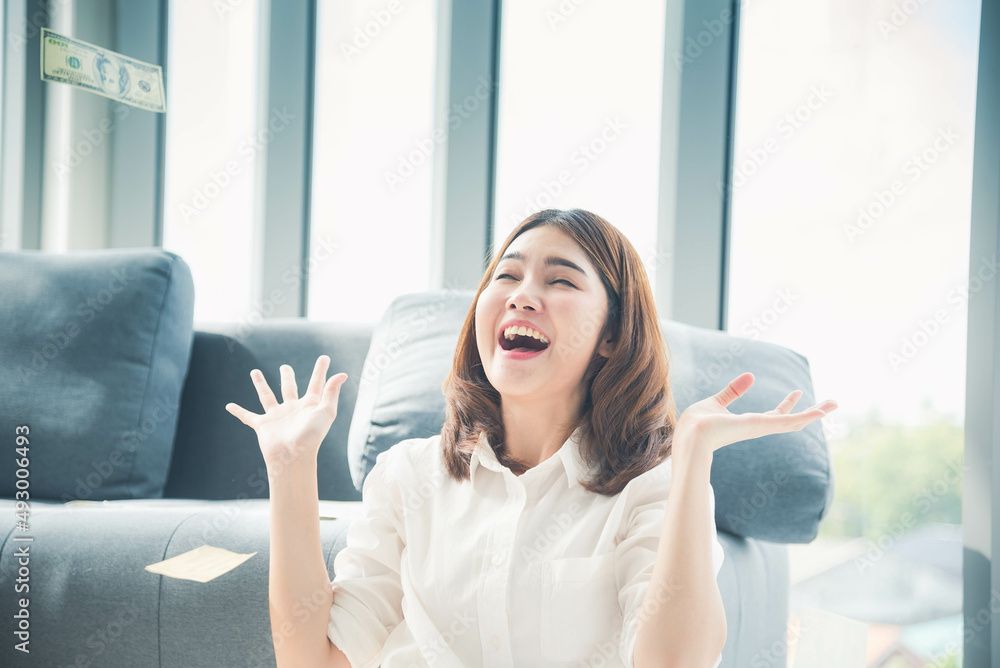 Happy young asian woman holding dollar money and throw in the air celebrate happiness dance wealth lottery money rain drop. Winner Success business woman throw cash flow Happy money smiling face Happy young asian woman holding dollar money and throw in the air celebrate happiness dance wealth lottery money rain drop. Winner Success business woman throw cash flow Happy money smiling face