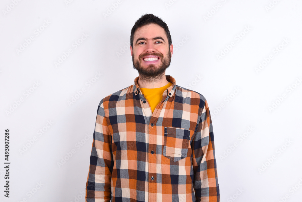 young caucasian man wearing plaid shirt over white background with nice beaming smile pleased expression. Positive emotions concept young caucasian man wearing plaid shirt over white background with nice beaming smile pleased expression. Positive emotions concept