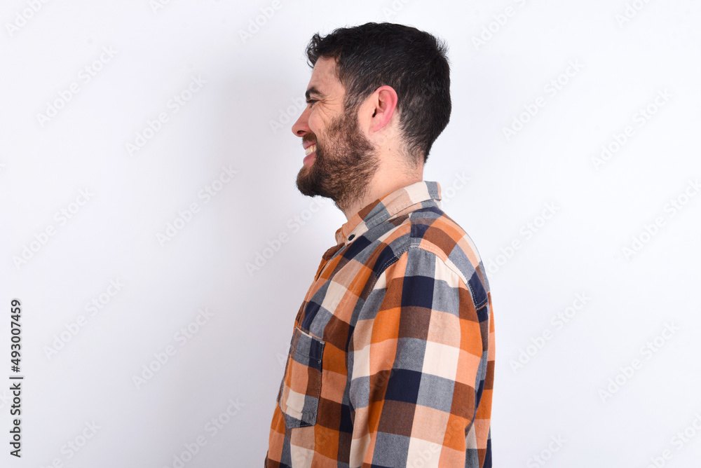 Fototapeta premium Profile portrait of nice young caucasian man wearing plaid shirt over white background look empty space toothy smile