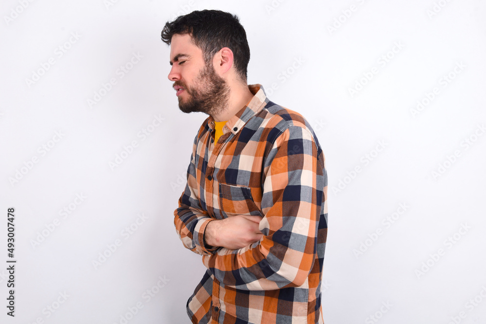 young caucasian man wearing plaid shirt over white background got stomachache young caucasian man wearing plaid shirt over white background got stomachache