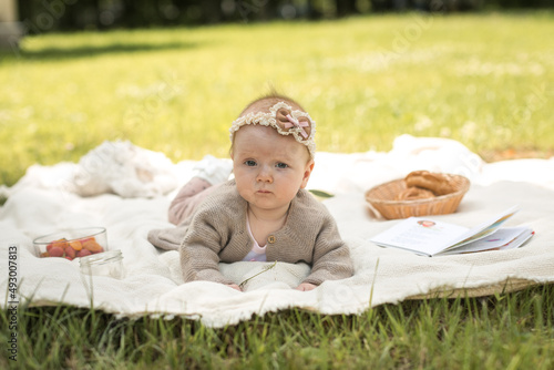 Obraz na płótnie little girl lies on a blanket at a summer picnic w salonie